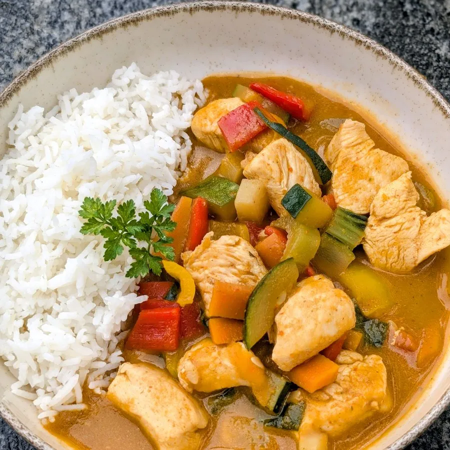 Huhn mit buntem Gemüse in Currysauce und Reis